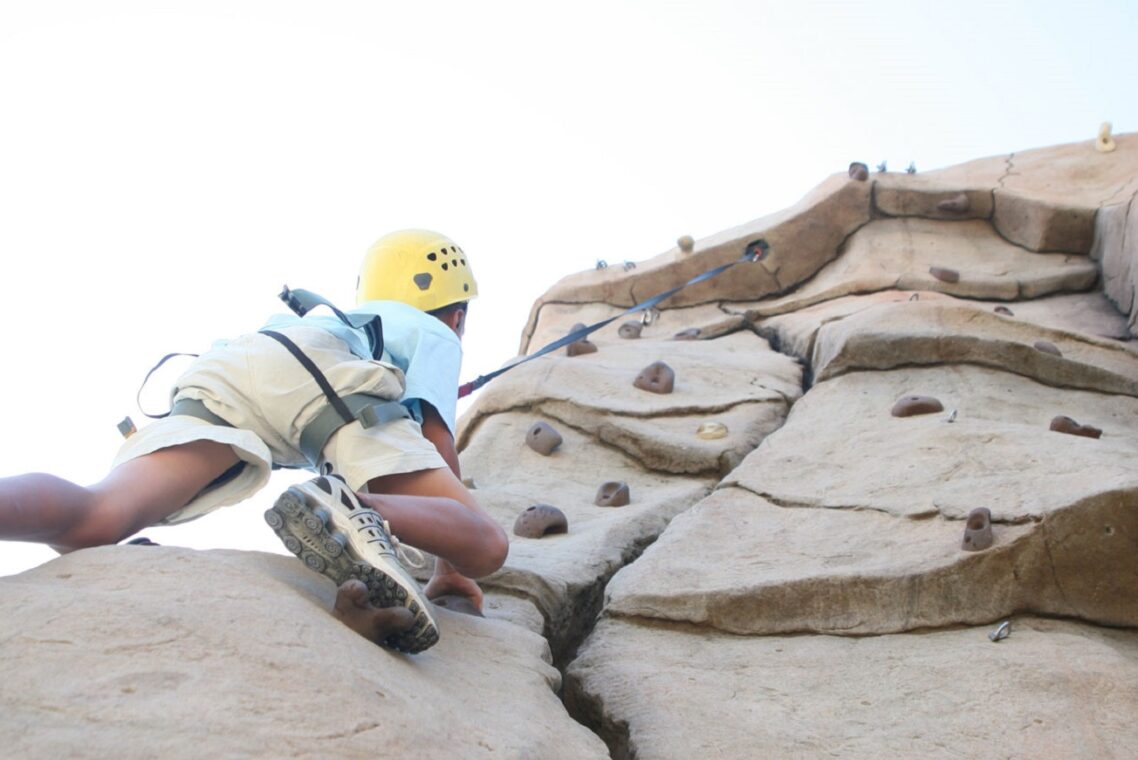 Child scaling a rock wall.