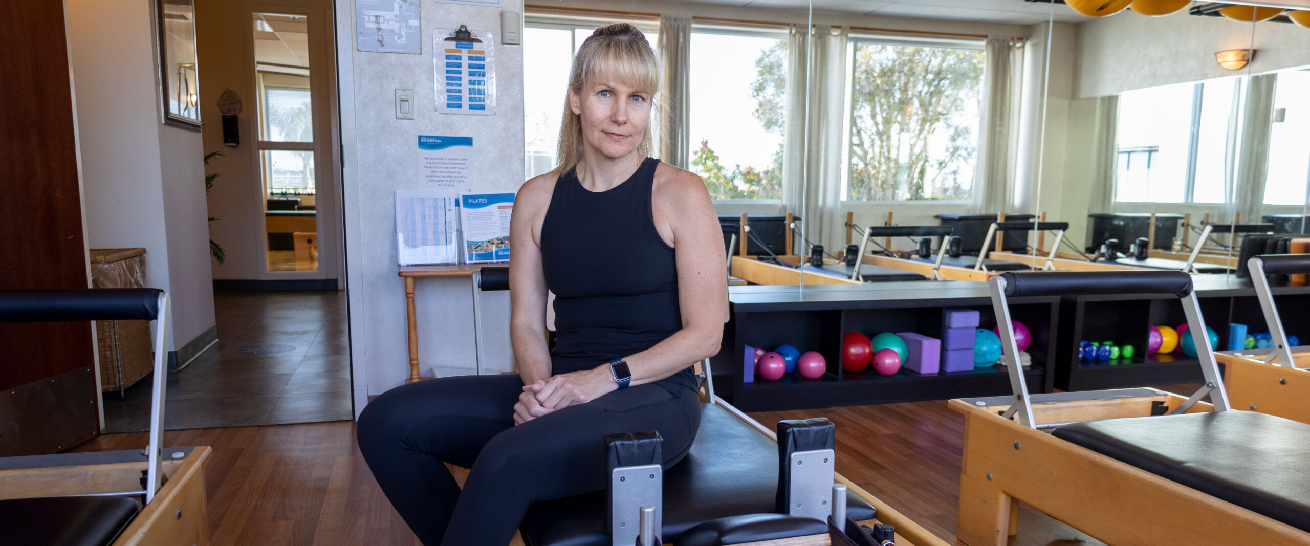 image of woman sitting on reformer pilates machine